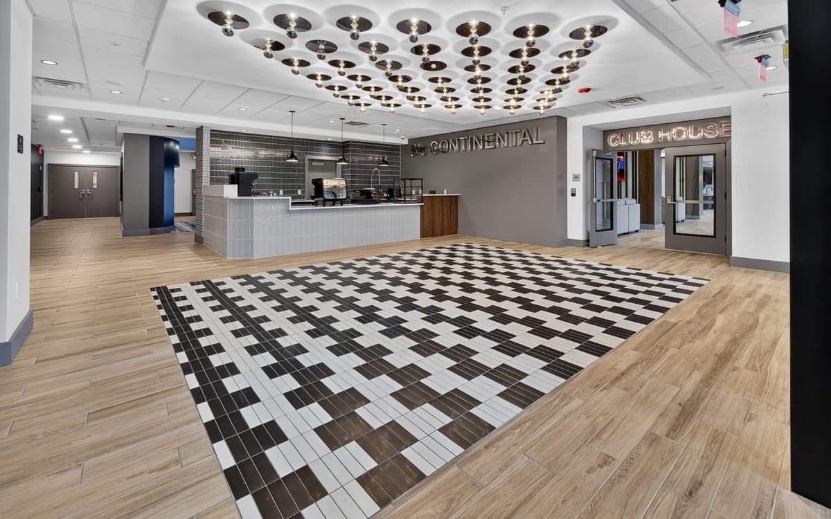 The identity carried into the building — lobby, Club House entry and the coffee bar.